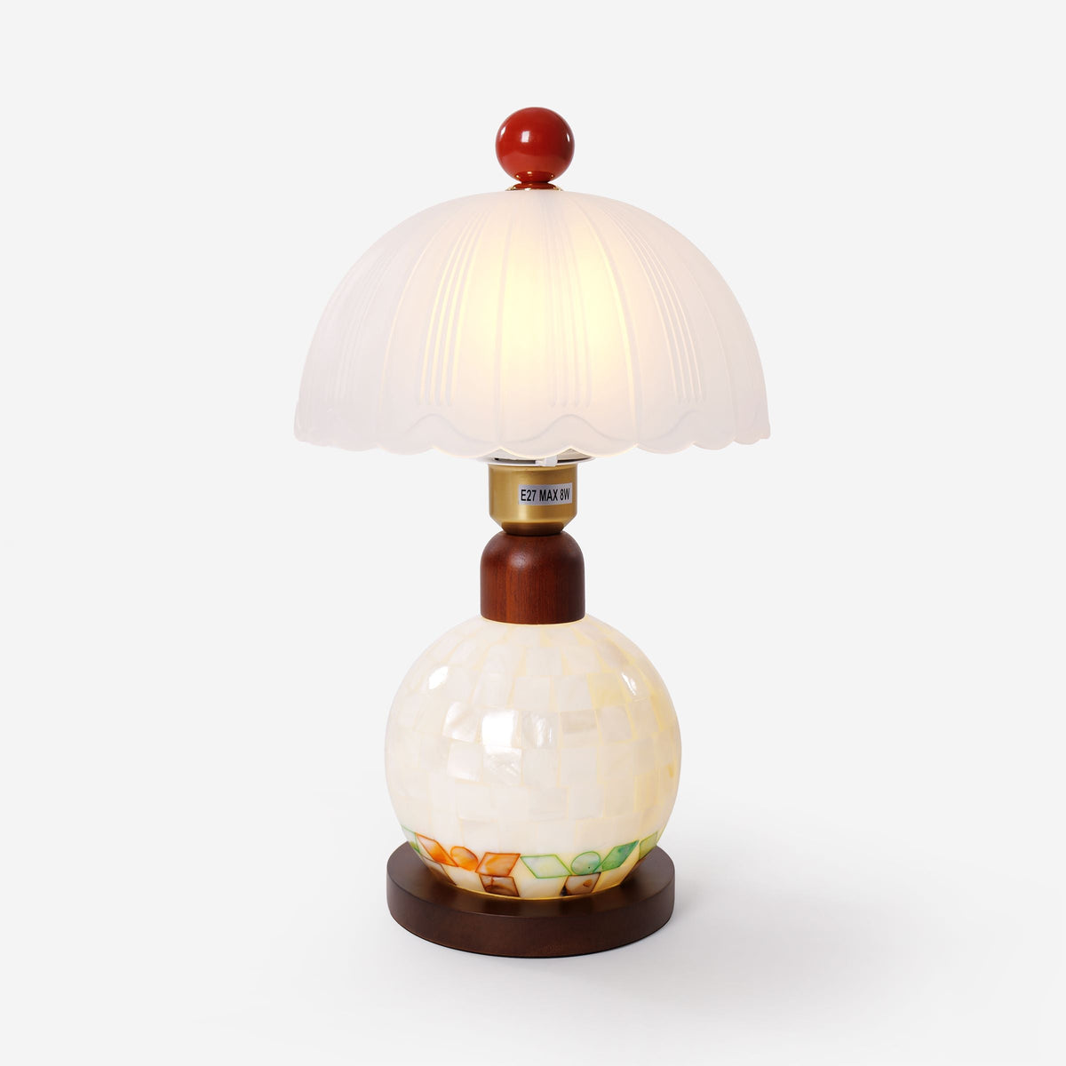 mother-of-pearl mosaic table lamp on a desk with soft ambient light