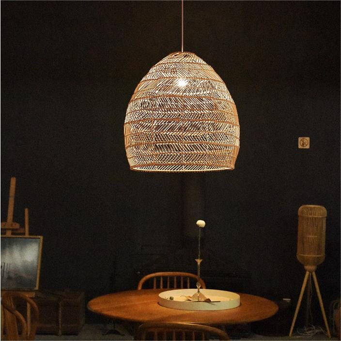 Natural rattan pendant light over a round dining table in a dark room