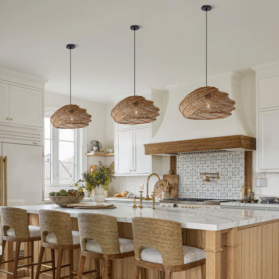 three spiral rattan pendant lights above a kitchen island with woven bar stools