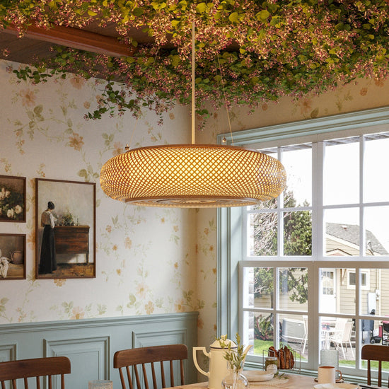 bamboo rattan pendant light above a dining table by a window