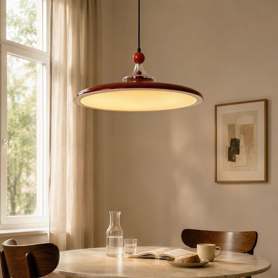 red iron pendant light hung above a dining table