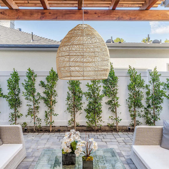 Natural rattan pendant light hanging above a bright patio seating area