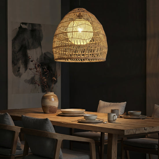 Rattan pendant light with inner sphere above a dark restaurant table