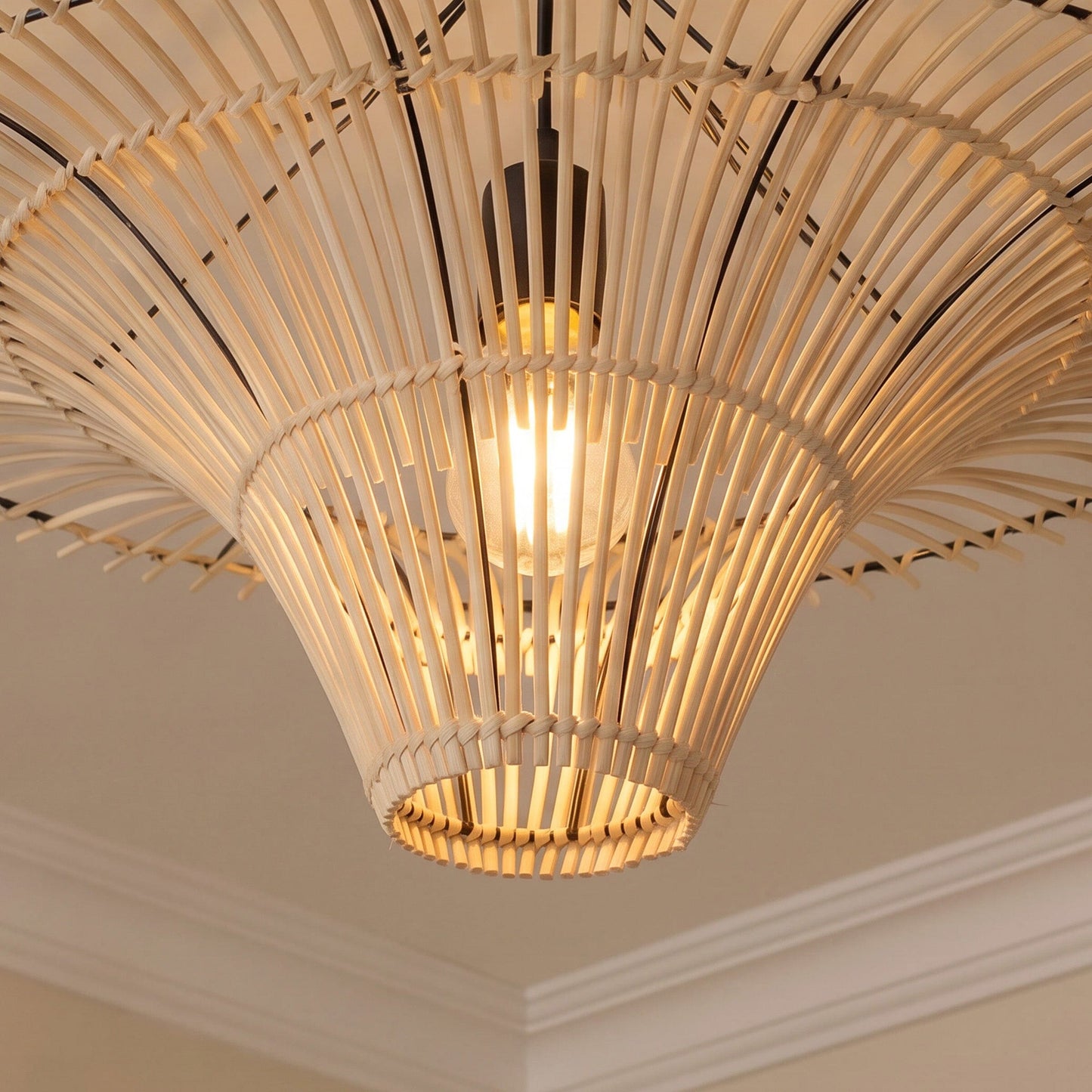 Underside close-up of woven rattan pendant shade with warm E27 bulb