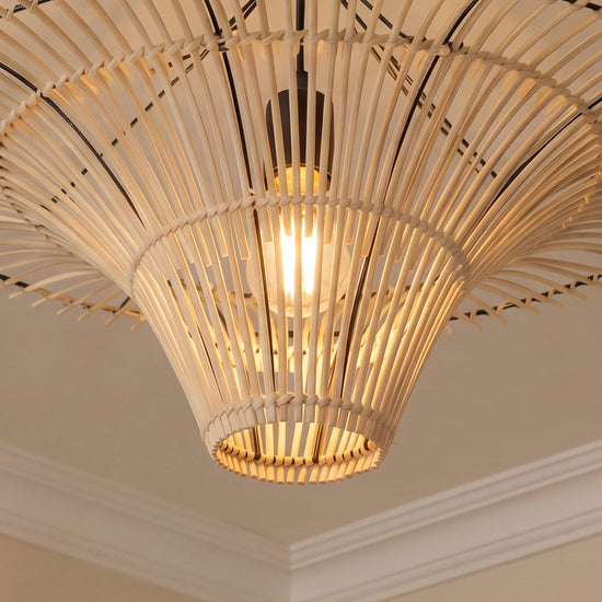Underside close-up of woven rattan pendant shade with warm E27 bulb