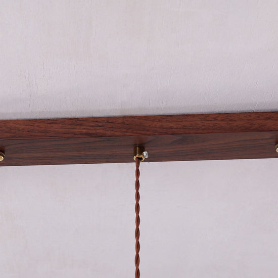 3-light walnut resin mini pendant adding warm light to a dining space