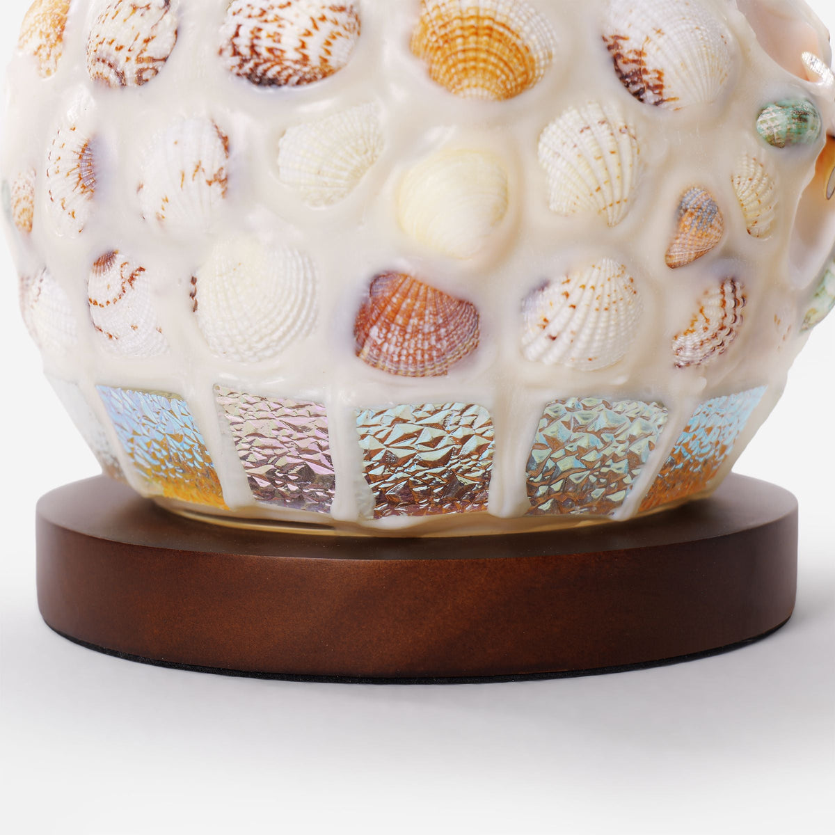 seashell mosaic table lamp adding warm light to a bedroom