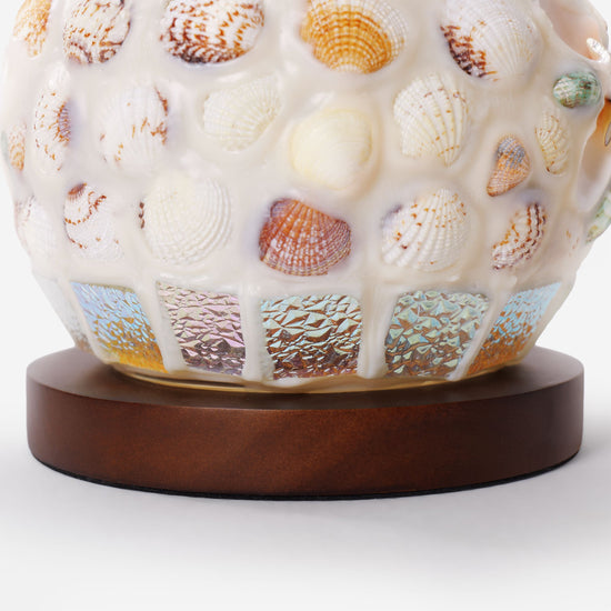 seashell mosaic table lamp adding warm light to a bedroom