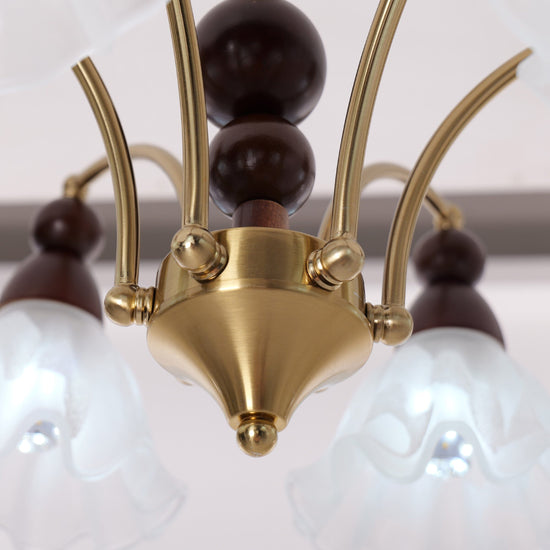 6-light chandelier with white glass shades glowing above a dining table