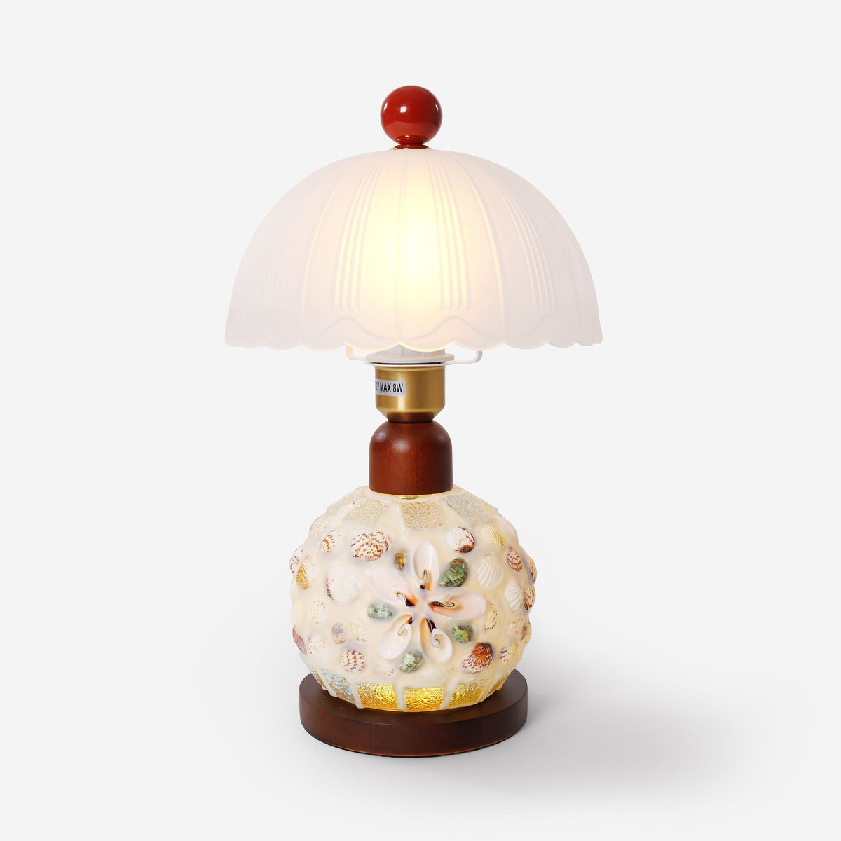 seashell mosaic table lamp on a desk with soft ambient light