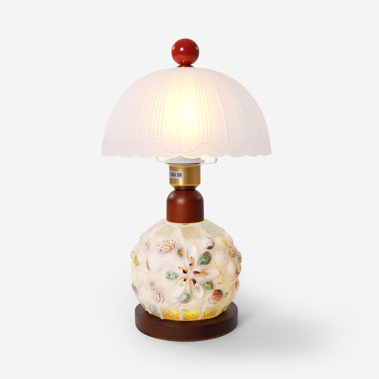 seashell mosaic table lamp on a desk with soft ambient light