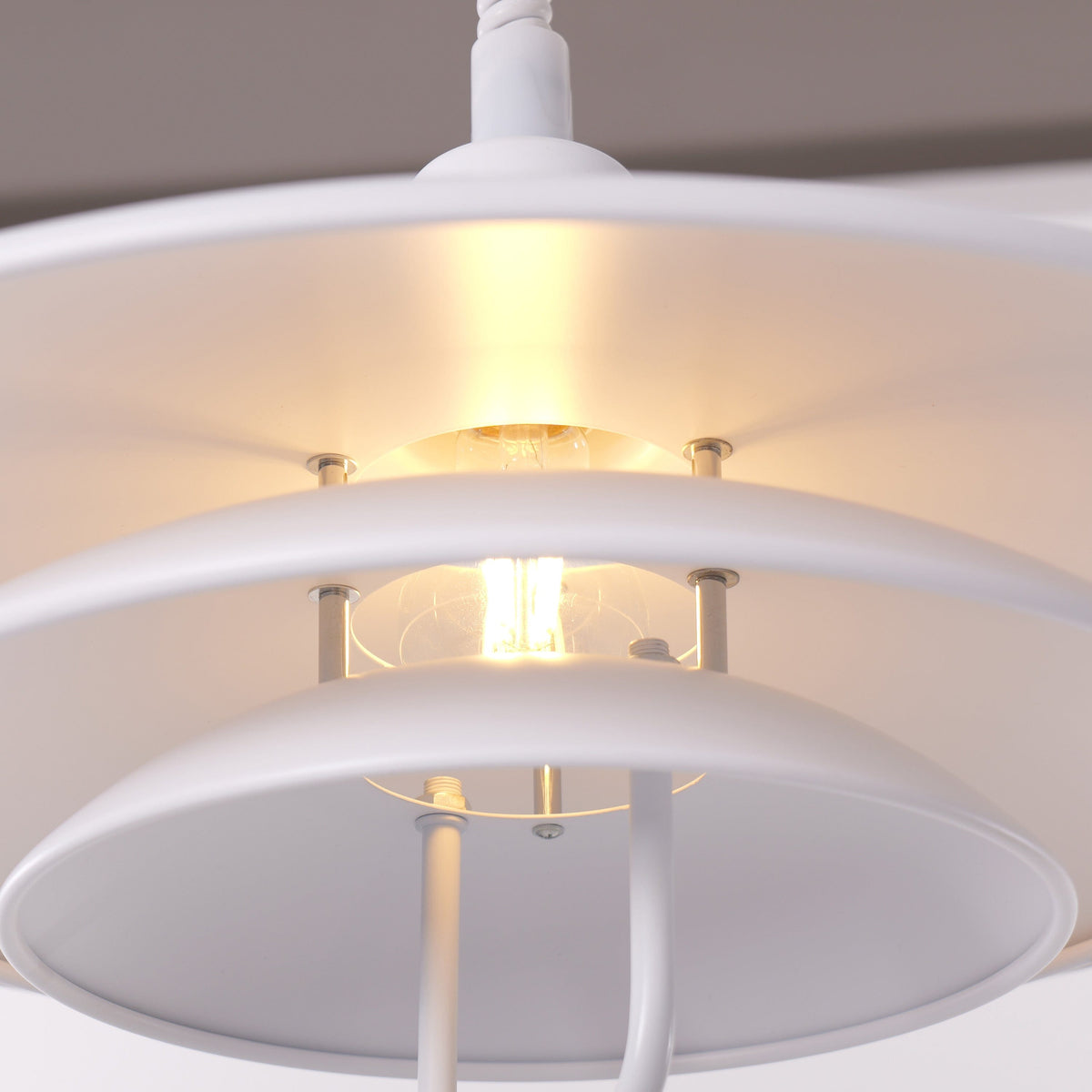 white layered minimalist pendant light hung above a dining table