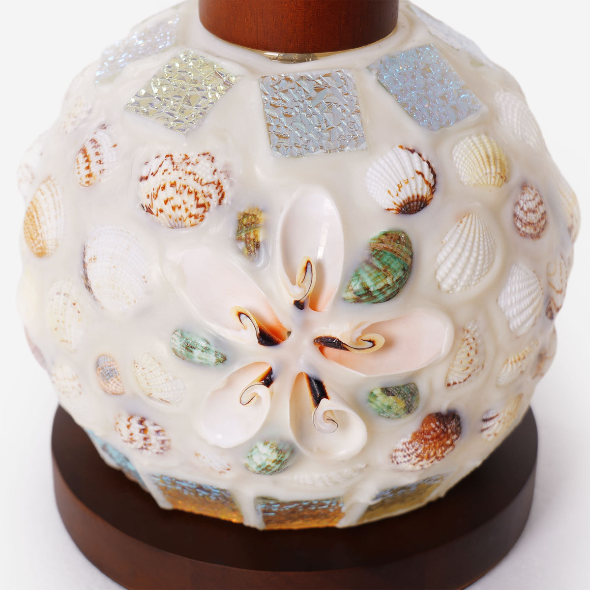 seashell mosaic table lamp glowing on a bedside table