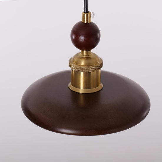 3-light walnut wood mini pendant hung above a dining table