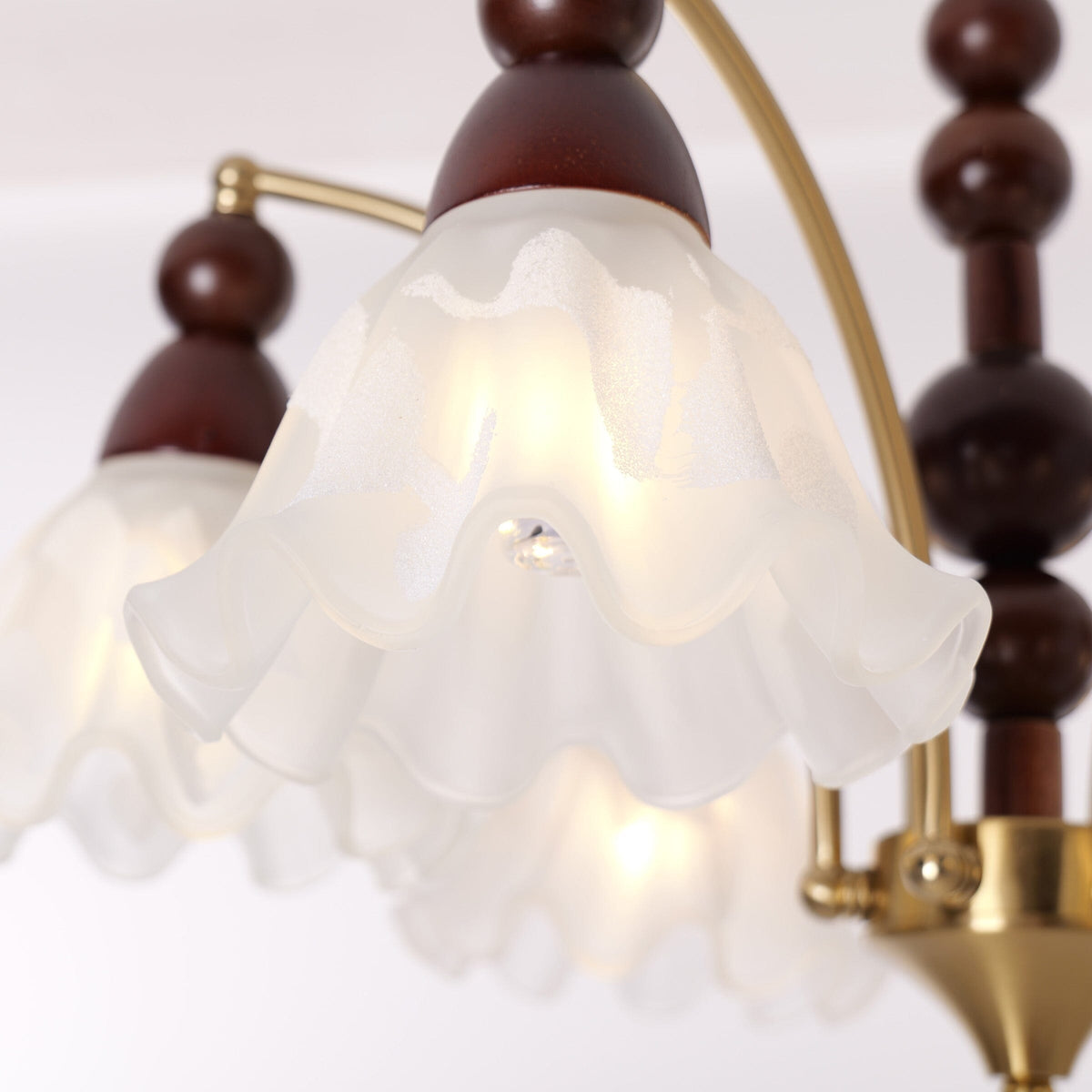 6-light chandelier with white glass shades adding soft light to a bedroom