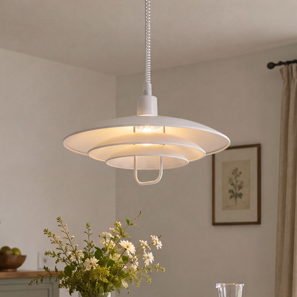 white layered minimalist pendant light hung above a dining table