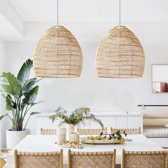 Two natural rattan pendant lights above a light dining table
