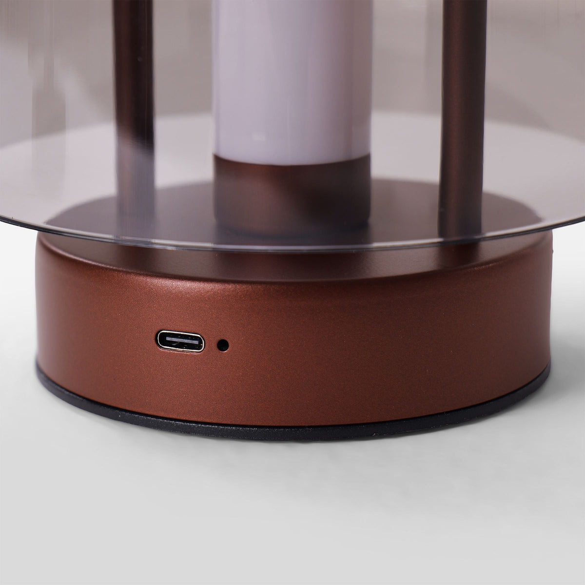 portable lantern-style ambient table lamp glowing on a bedside table