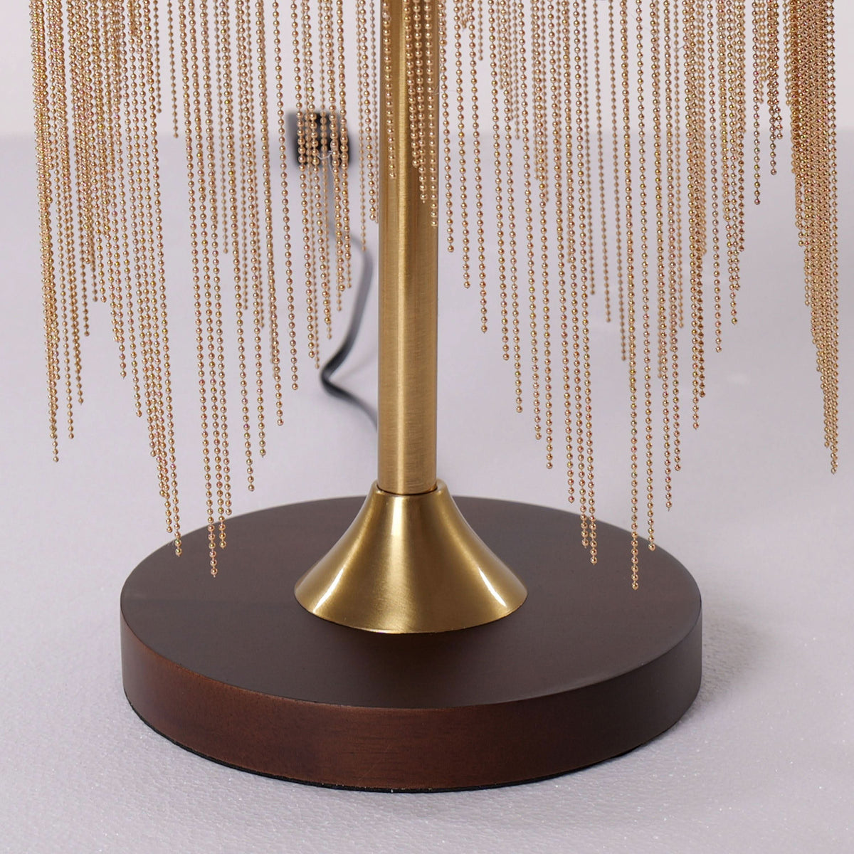 mid-century tassel table lamp glowing on a bedside table
