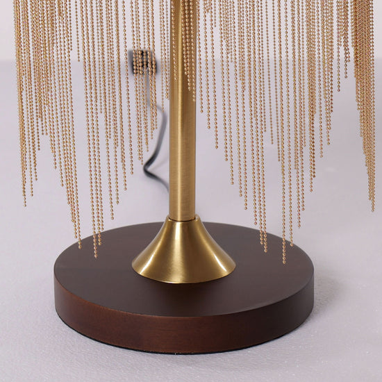 mid-century tassel table lamp glowing on a bedside table