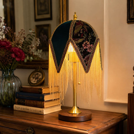 mid-century tassel table lamp glowing on a bedside table