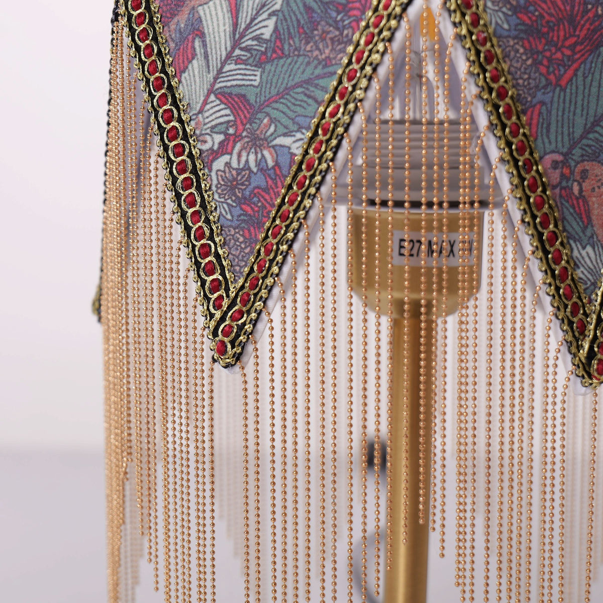 mid-century tassel table lamp glowing on a bedside table