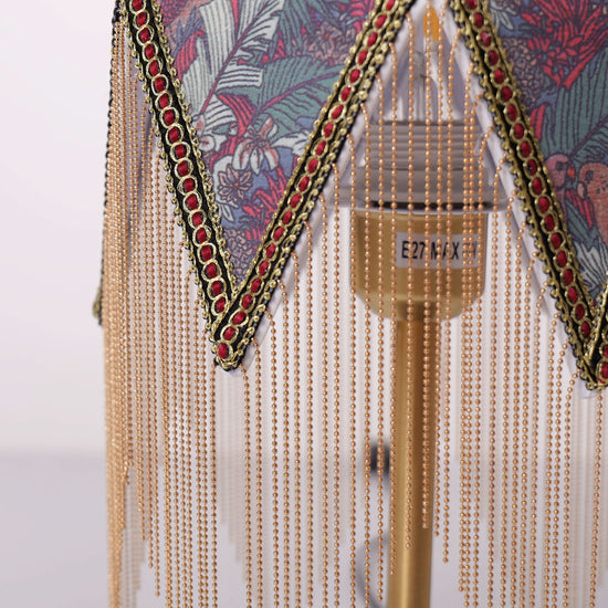 mid-century tassel table lamp glowing on a bedside table