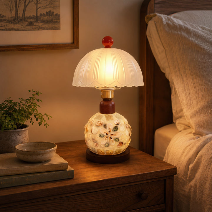 seashell mosaic table lamp glowing on a bedside table