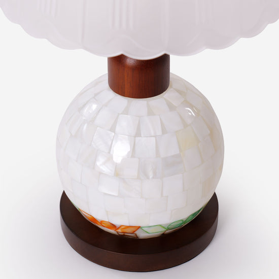 mother-of-pearl mosaic table lamp glowing on a bedside table