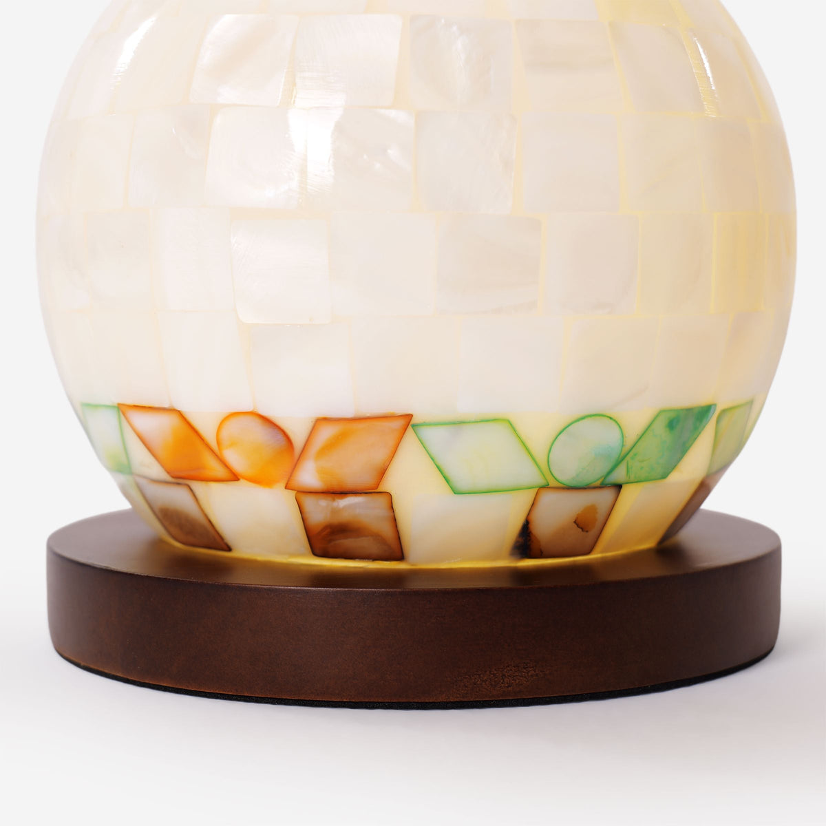mother-of-pearl mosaic table lamp adding warm light to a bedroom