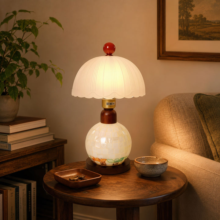 mother-of-pearl mosaic table lamp glowing on a bedside table