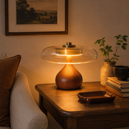 ash wood and glass table lamp glowing on a bedside table