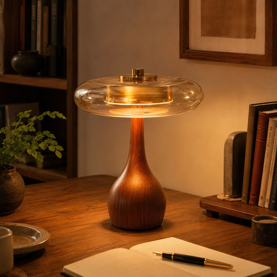 ash wood and glass table lamp glowing on a bedside table