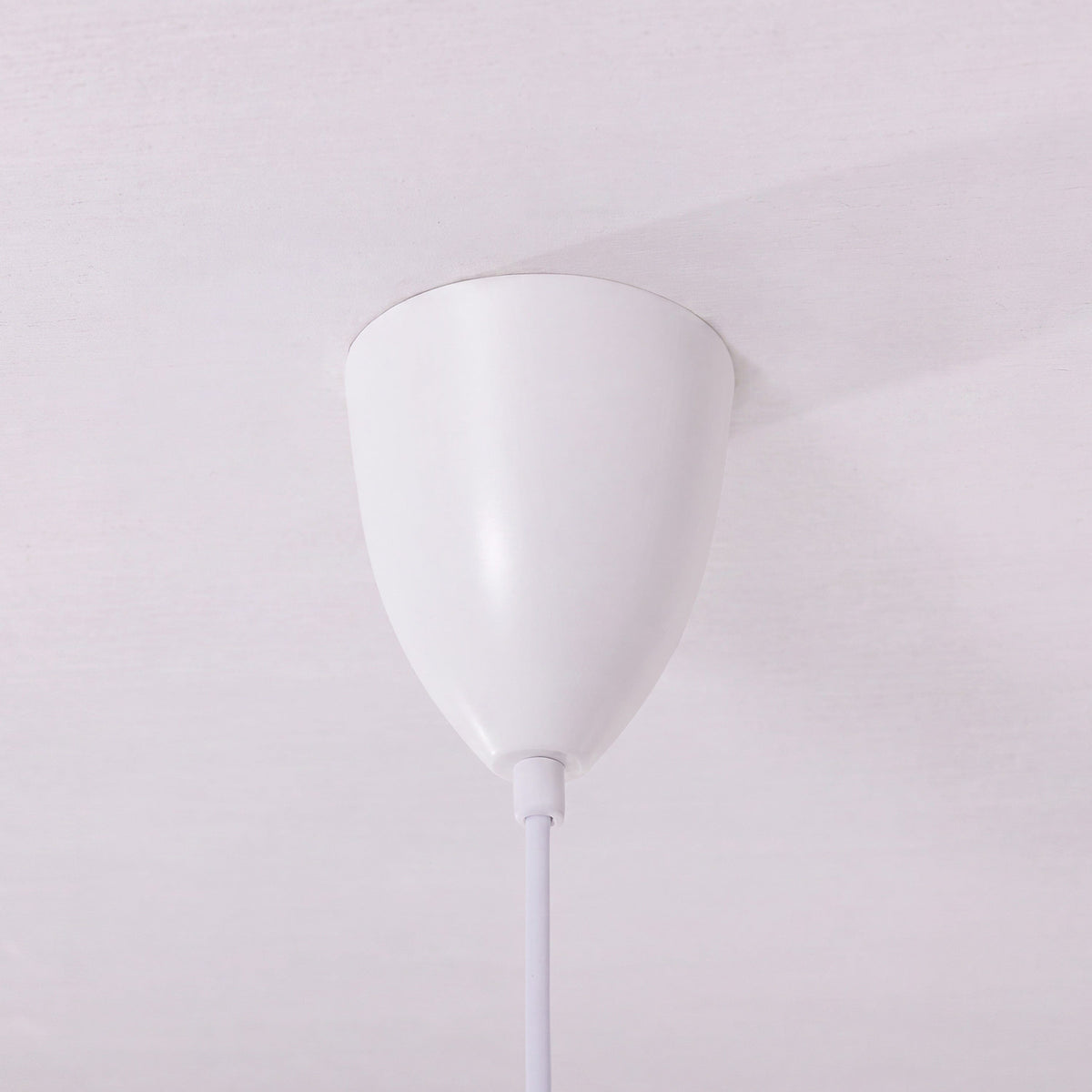 white layered minimalist pendant light adding warm light to a dining space