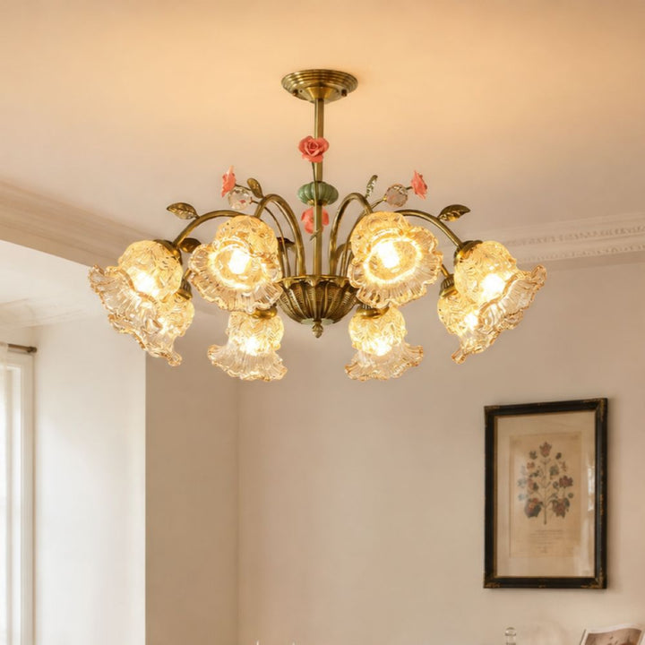 gold 8-light chandelier with pink floral glass shades glowing above a dining table