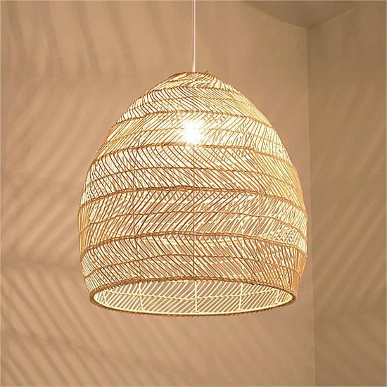 Close-up of woven rattan pendant shade glowing with a warm E27 bulb