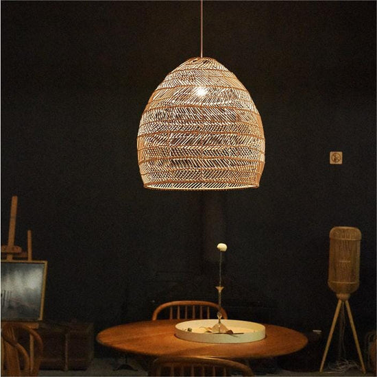 Natural rattan pendant light over a round dining table in a dark room