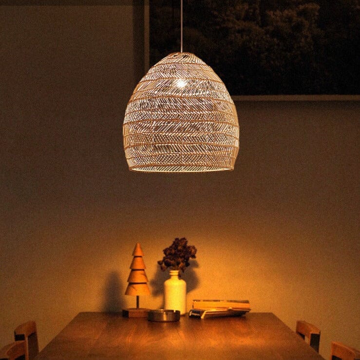 Warm rattan pendant light above a simple wooden table vignette