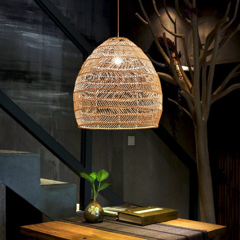 Rattan pendant light above a small table beside a dark stairway