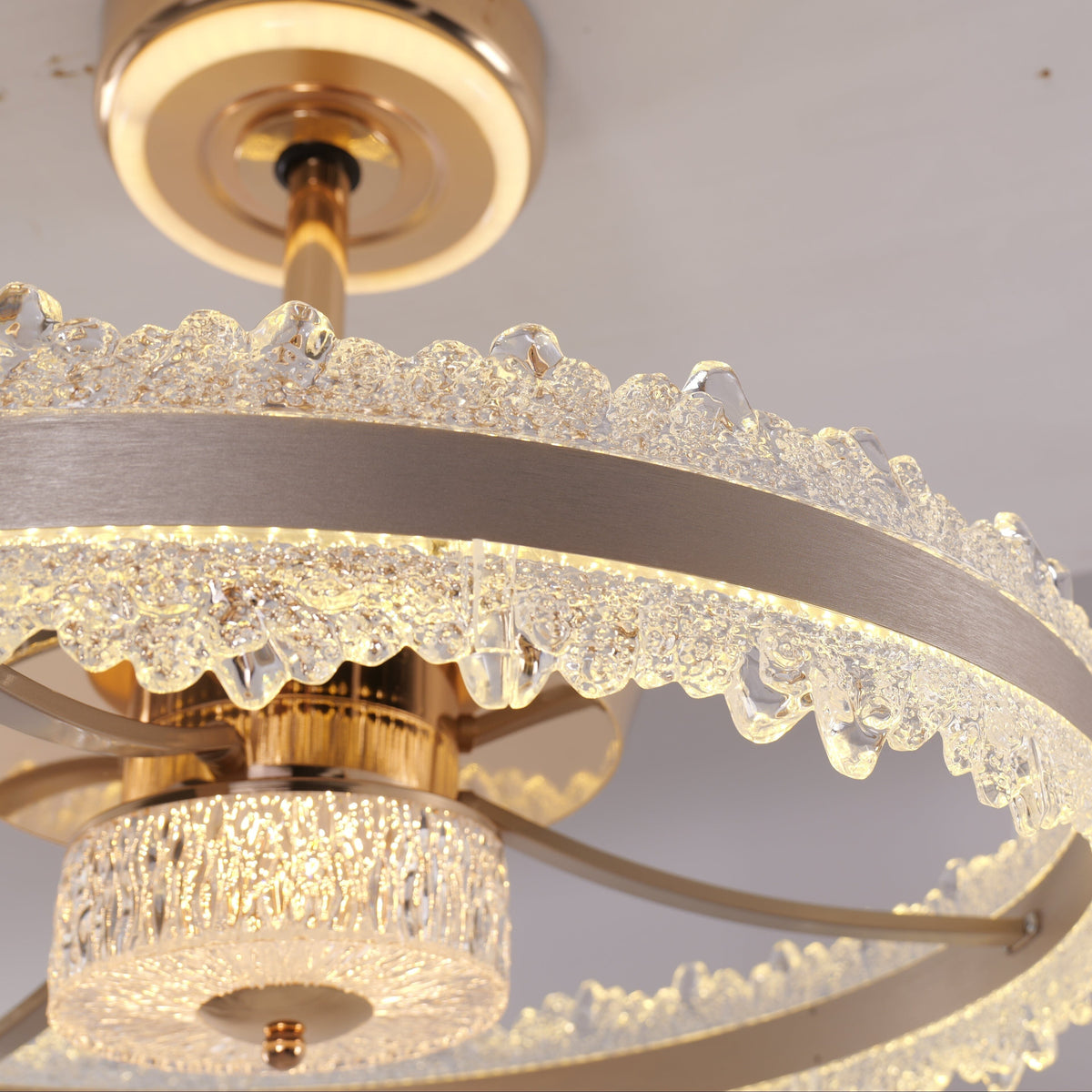 Faceted crystal ring and brushed gold frame close-up on LED fan light