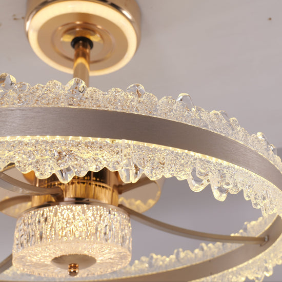 Faceted crystal ring and brushed gold frame close-up on LED fan light