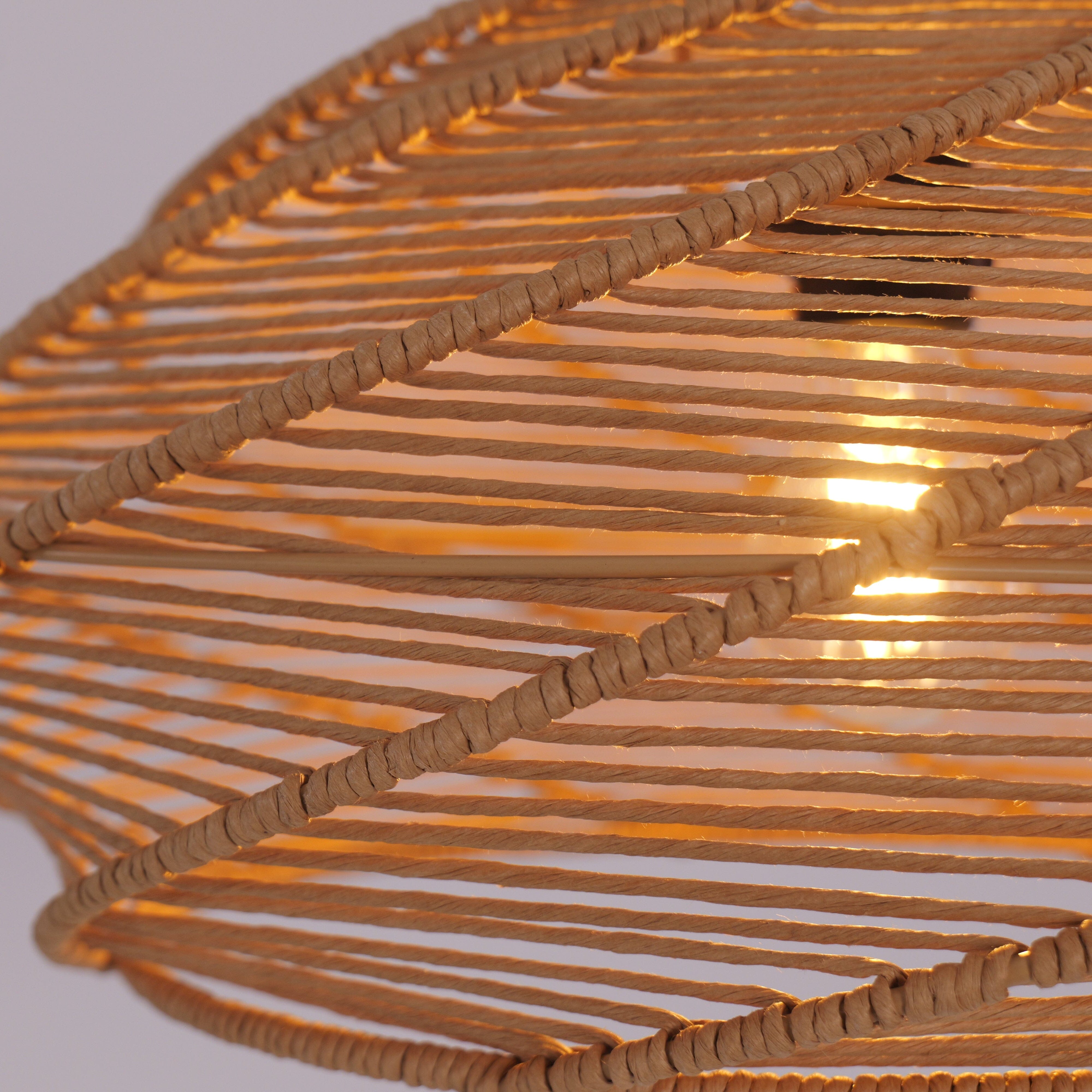 close-up of spiral rattan pendant shade with warm bulb glowing through slats